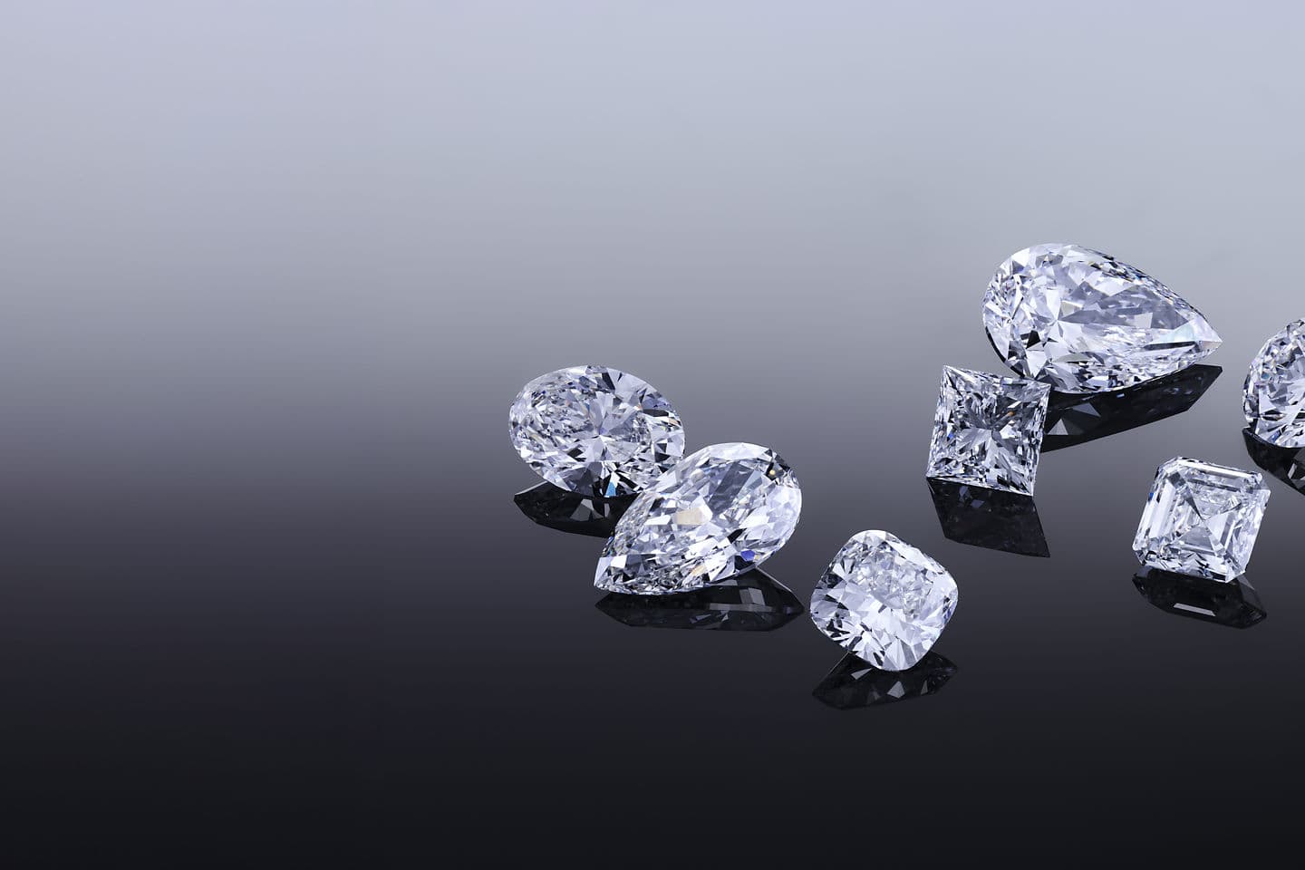 Loose lab-grown diamonds on a dark surface